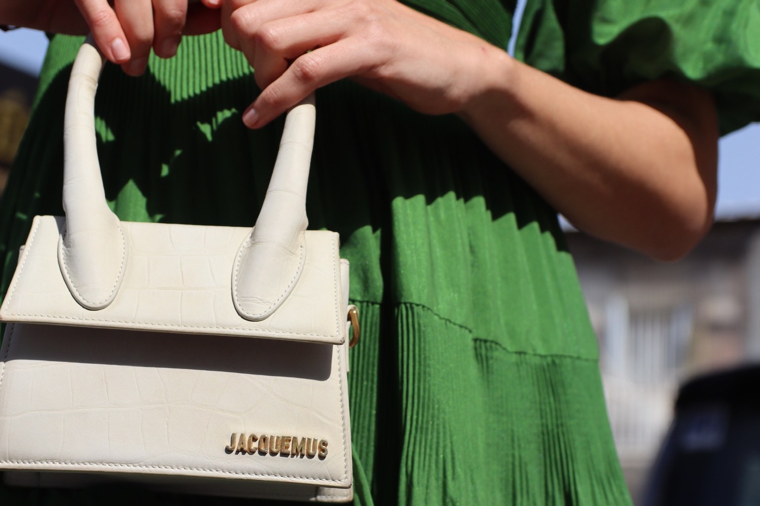Eva Circular Luxury — a cream leather bag against a green pleated dress