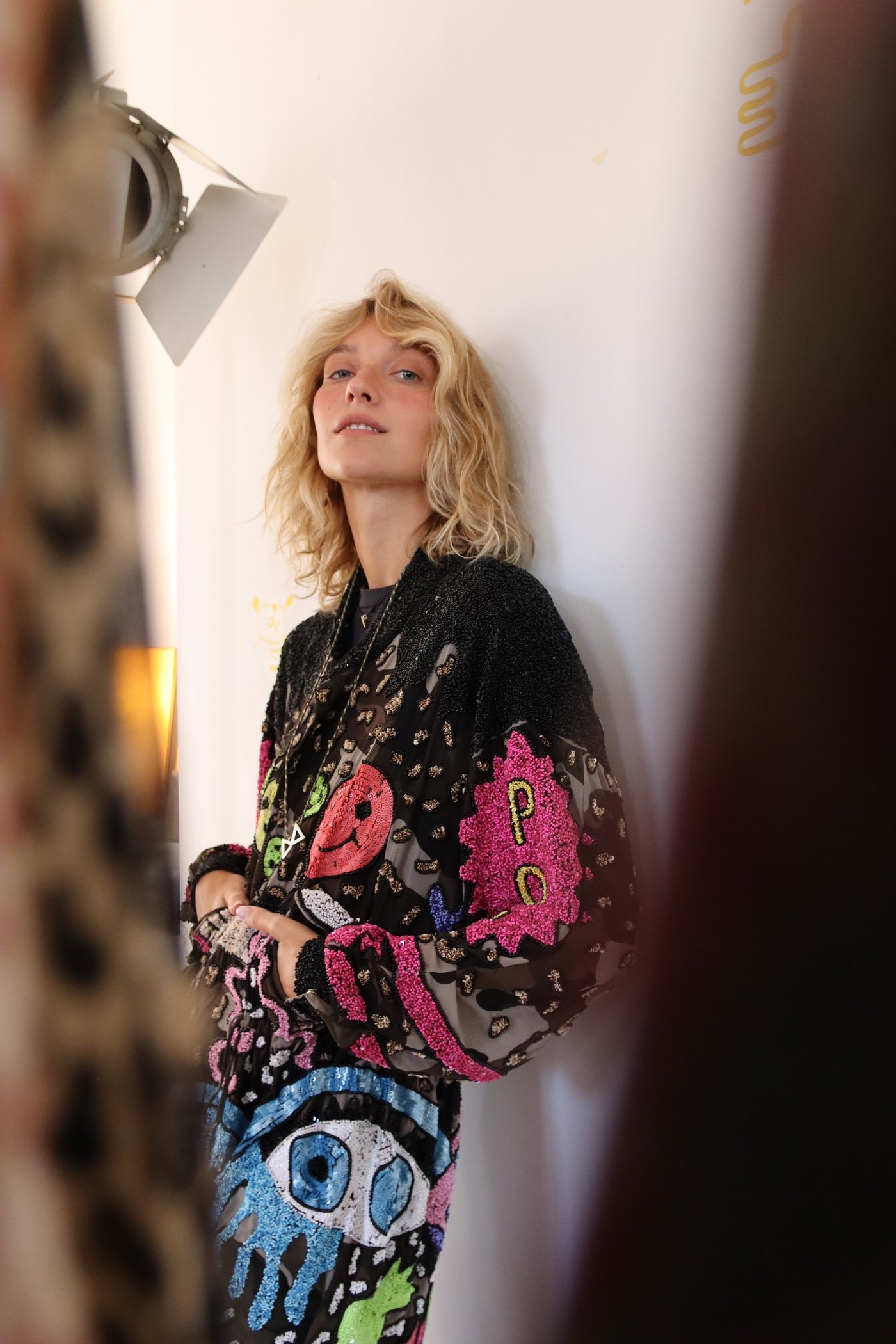 The embroidered jacket, against the wall