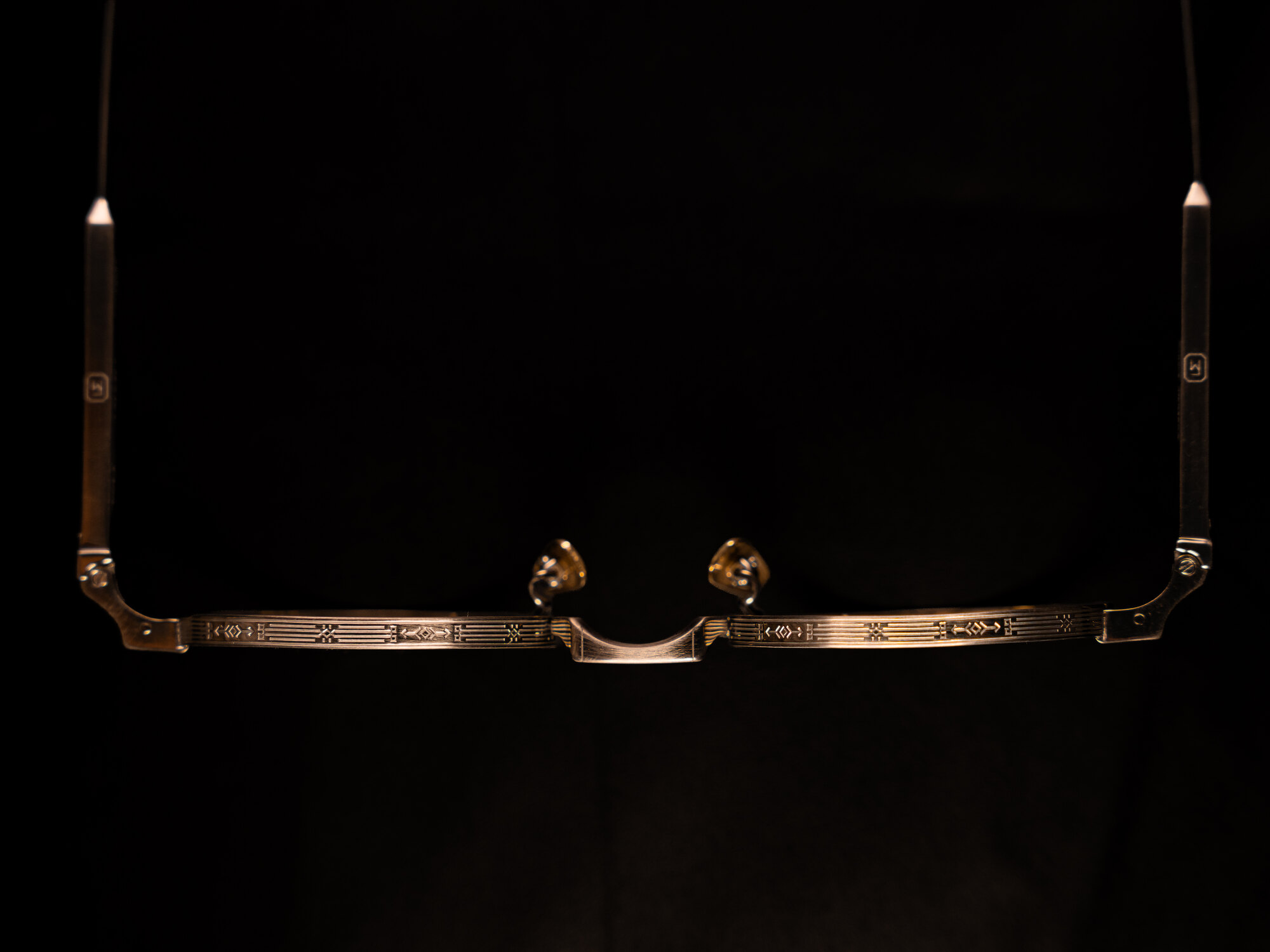 Frame Montana — an engraved gold frame lit against black