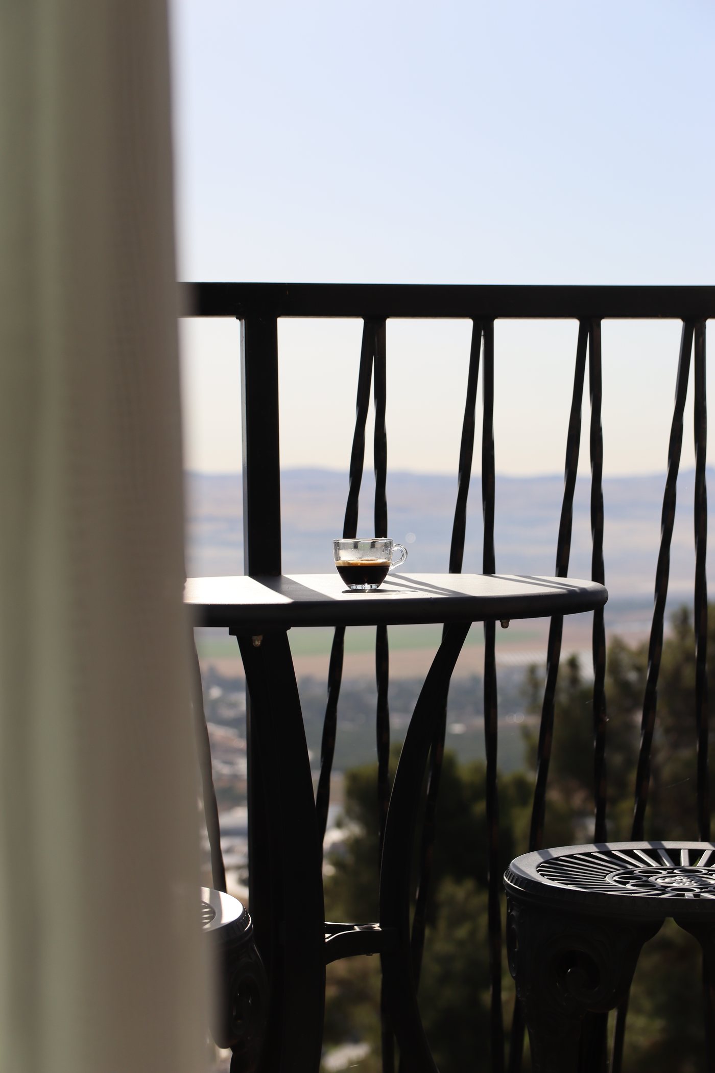 A coffee on a balcony table, the valley beyond