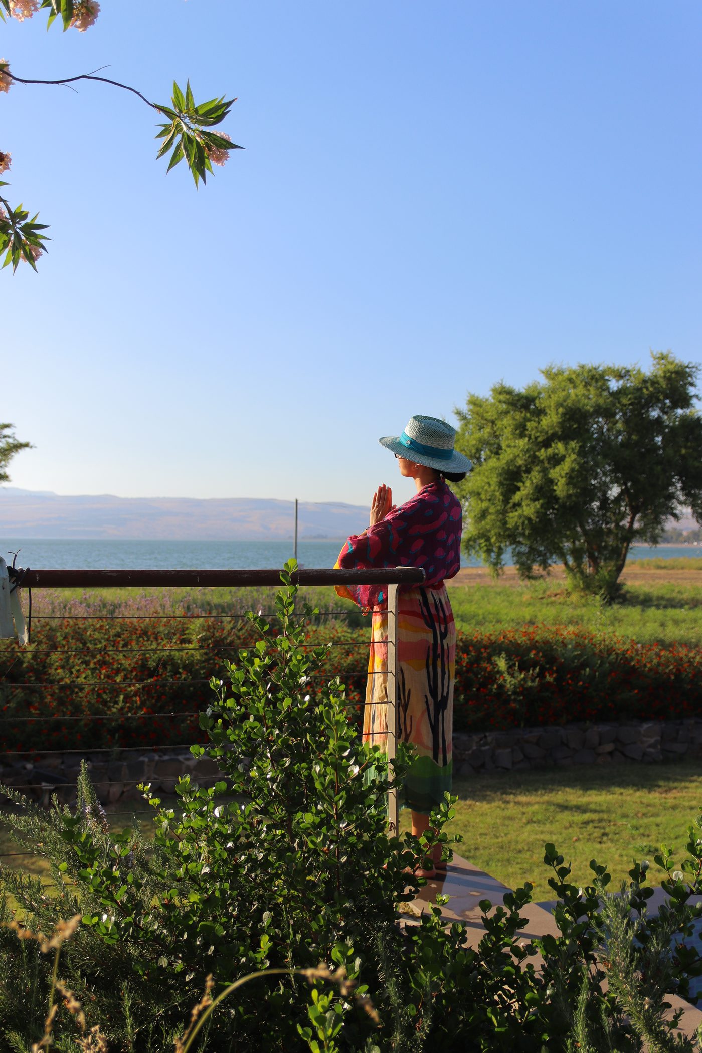 A guest in a hat looking out over the Sea of Galilee