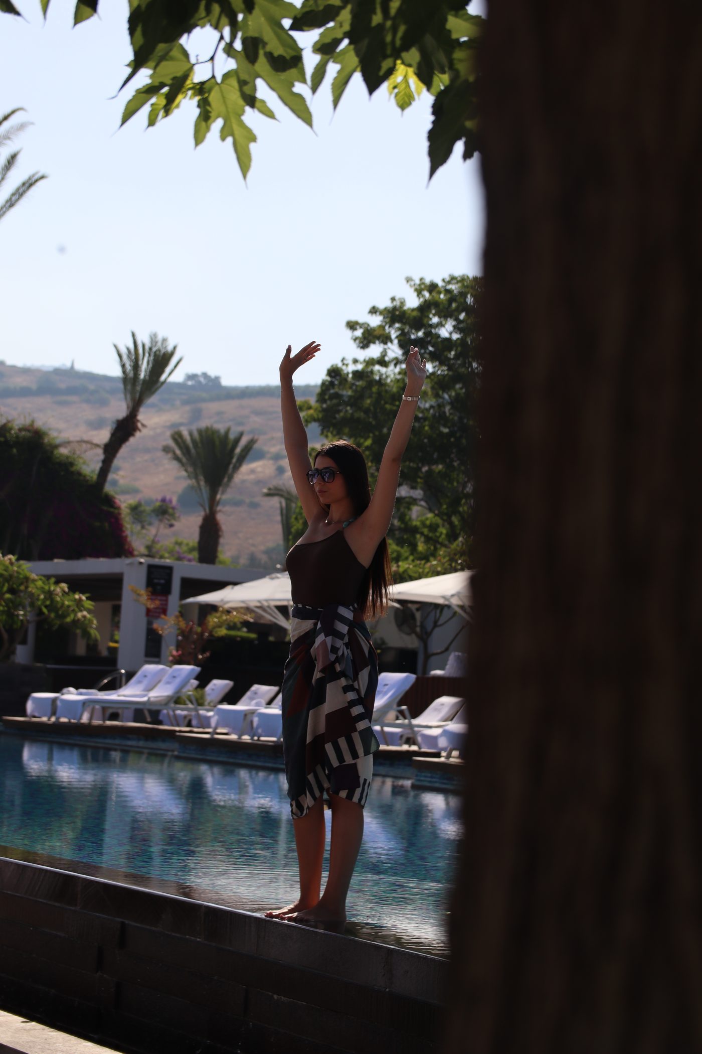 A guest at the pool, framed by the trees