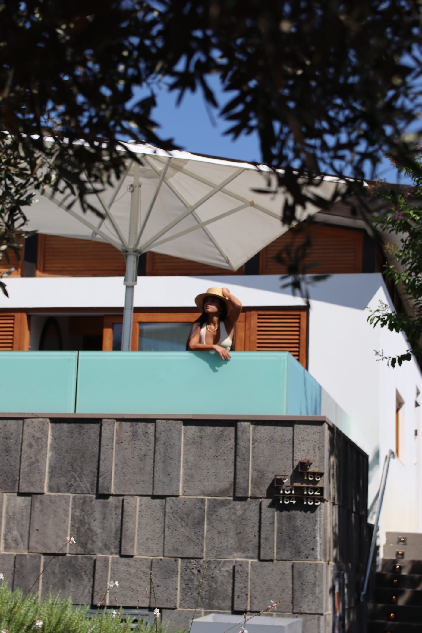 A villa and its private pool, a guest at the window