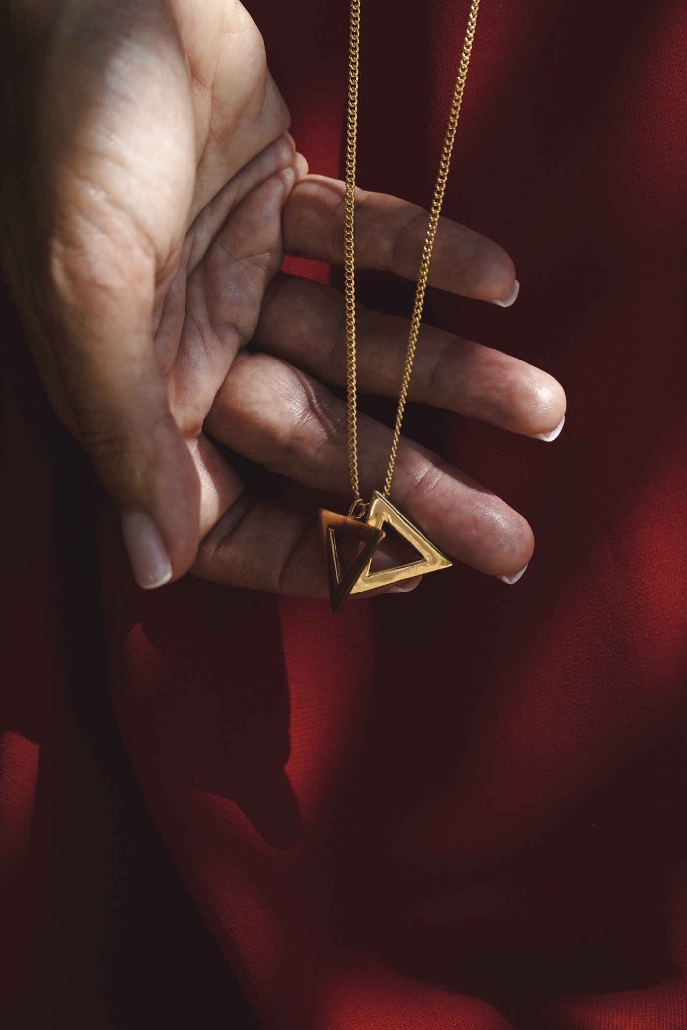 The triangle pendant held in the hand